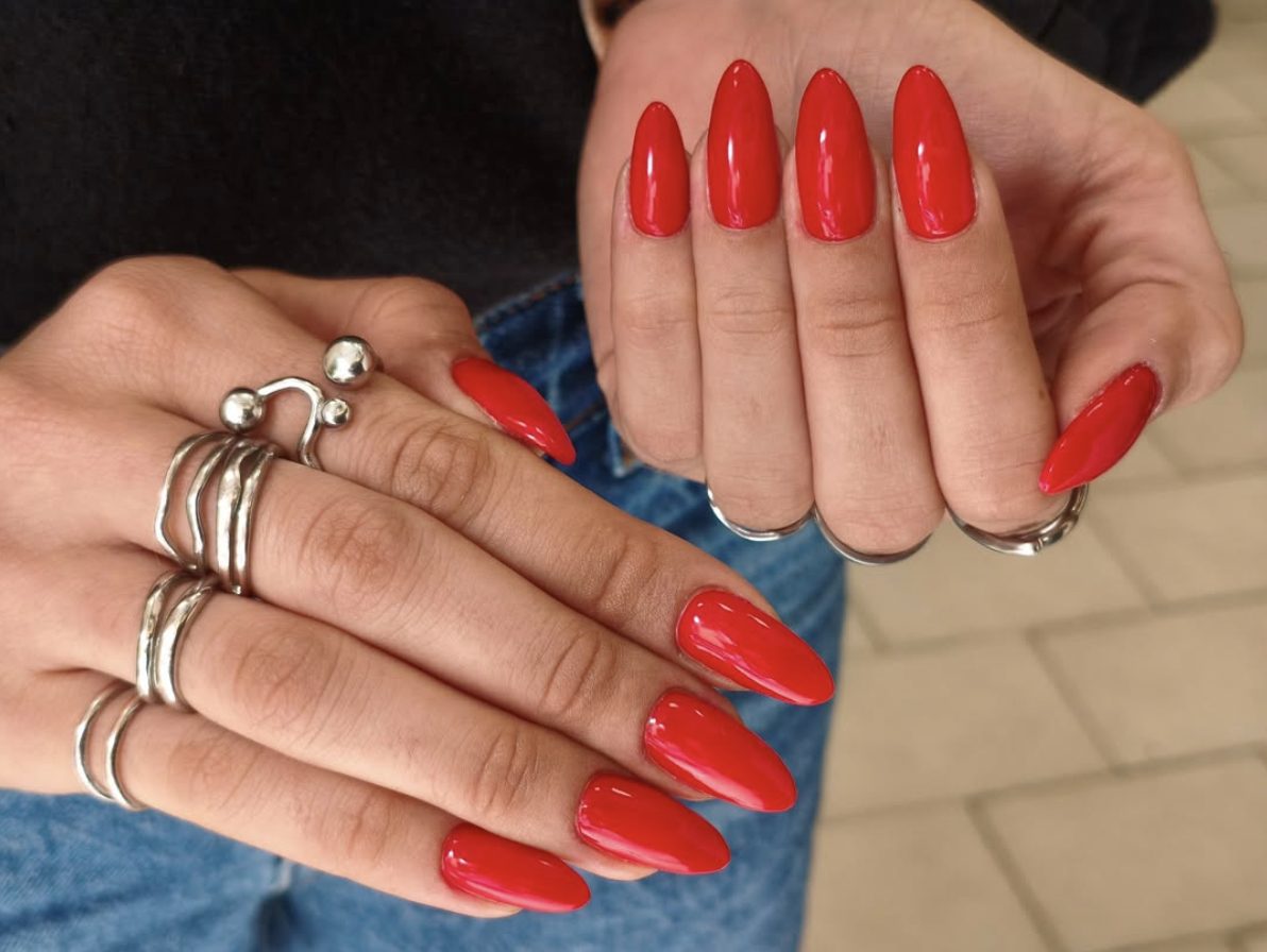 Glossy bright red almond manicure with solid color finish