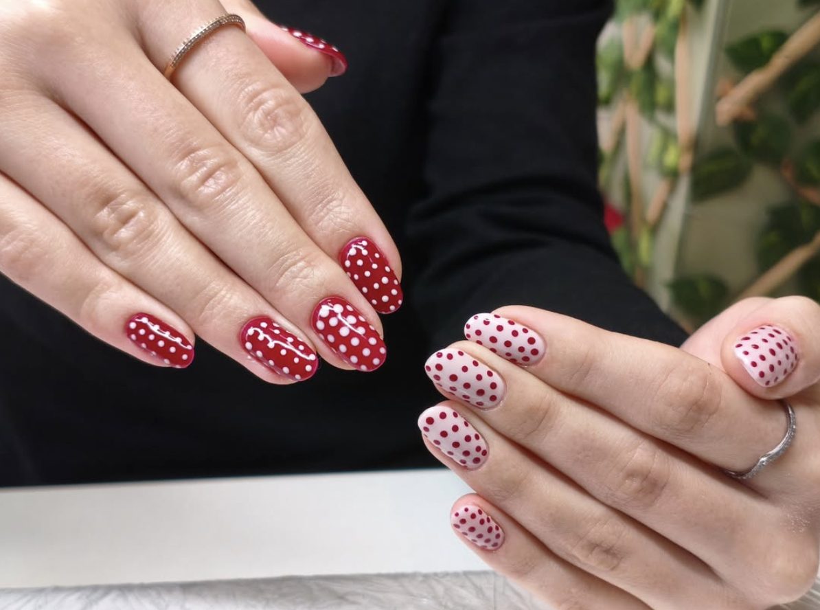 Red and white polka dot nail art on short almond nails
