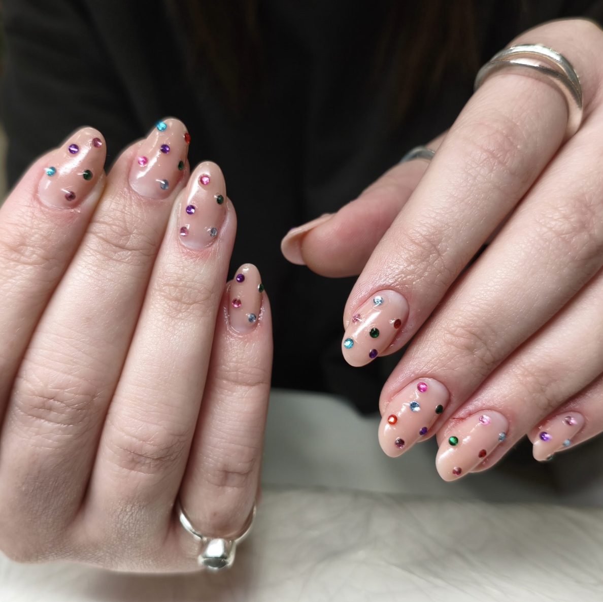 Nude almond manicure with multicolored rhinestone crystal nail art