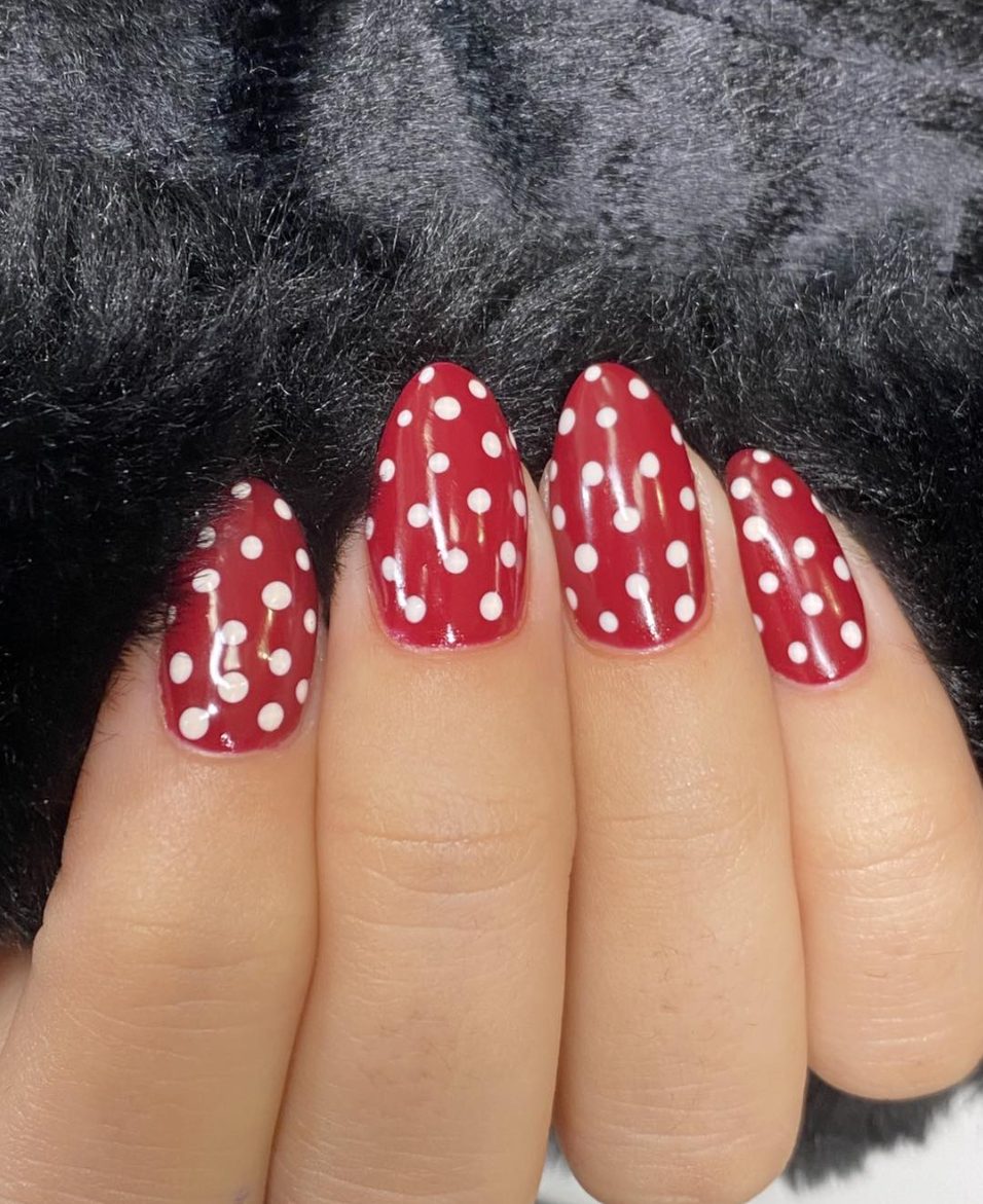 Deep red almond manicure with white polka dot nail art